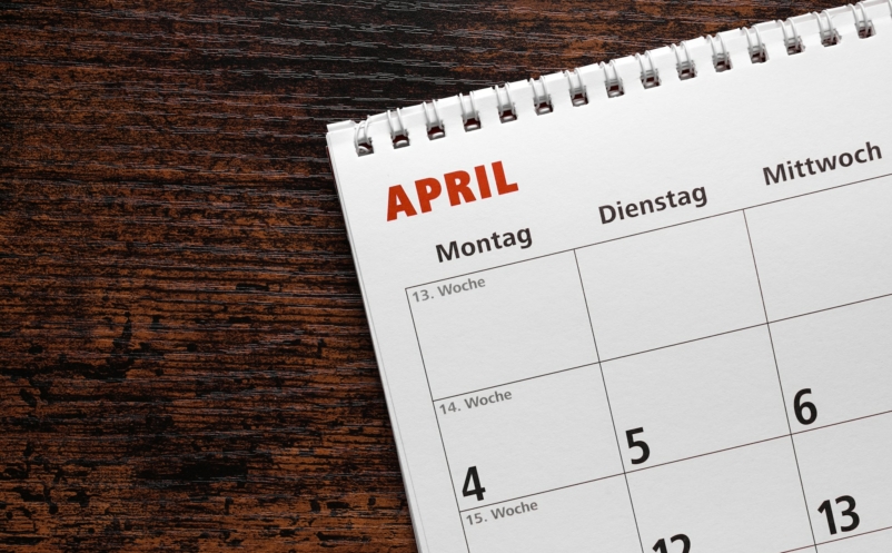 month of april in german calendar or planner on wooden desk background with copy space